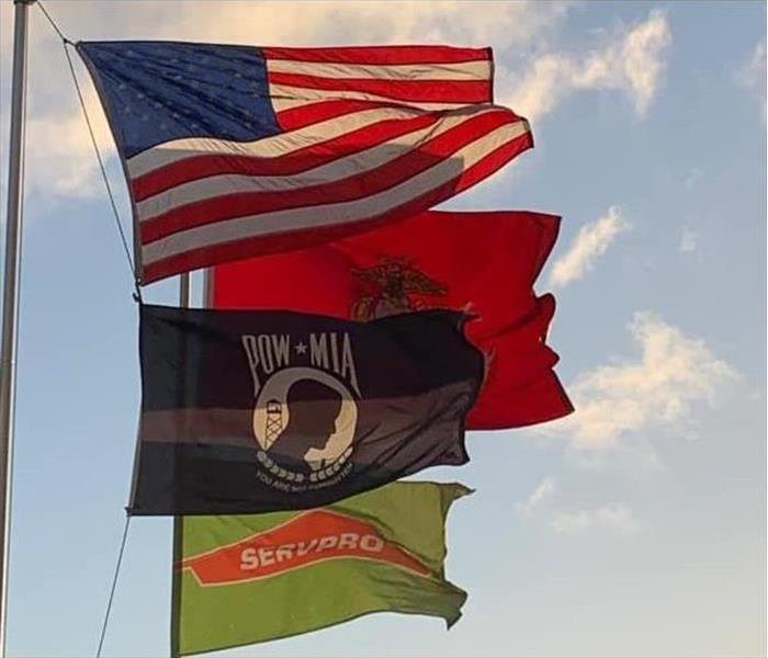 American, POWMIA, SERVPRO, USMC flags in wind