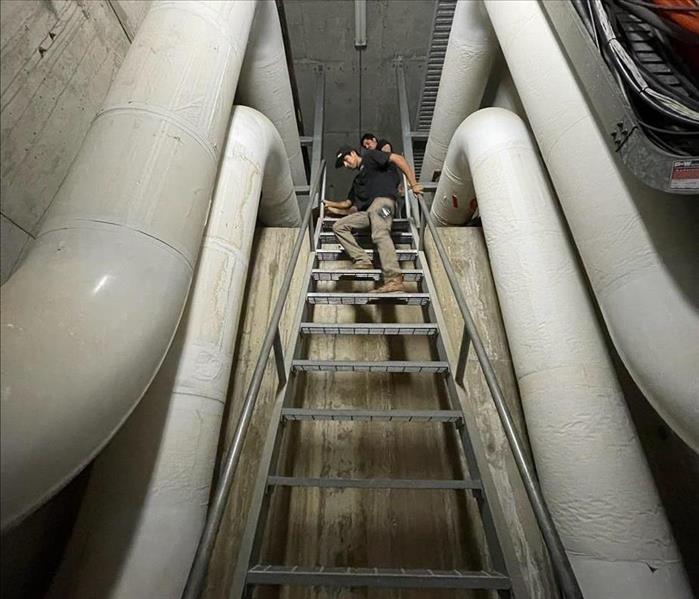 Our team descending underground, ready to tackle a challenging water damage restoration project